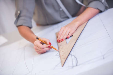 Cropped image of attractive fashion designer drawing sketch while working in her officeの写真素材
