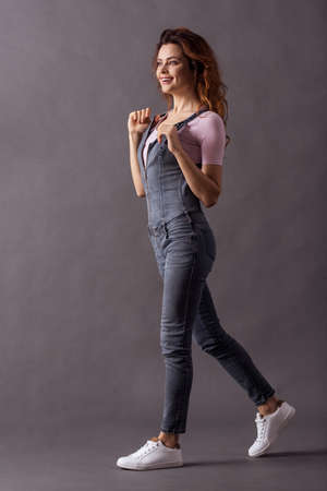 Portrait of a young beautiful woman full of growth on a gray background to go forward and a smile to the cameraの写真素材