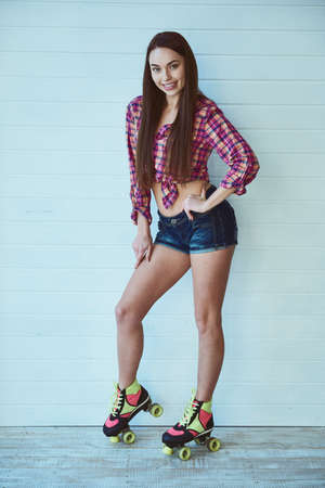 Portrait of young beautiful girl with long hair with rollers on legs on gray backgroundの写真素材