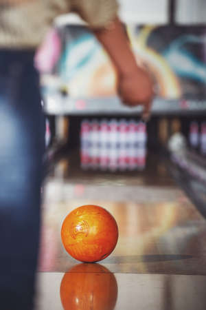 Young woman in club for bowling is throwing ball.の写真素材