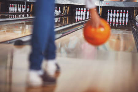 Young woman in club for bowling is throwing ball.の写真素材