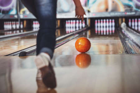 Woman in club for bowling is throwing ball.の写真素材