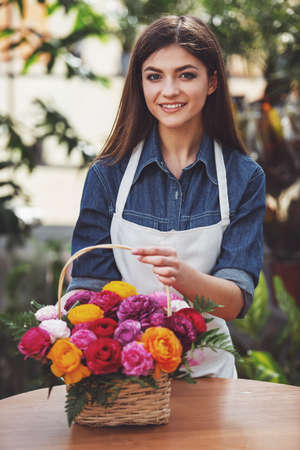 Young female florist making bouquet of flowers in shop.の写真素材