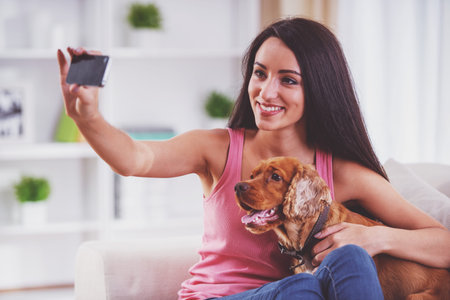 Young woman is making a picture with her cute dog pet.