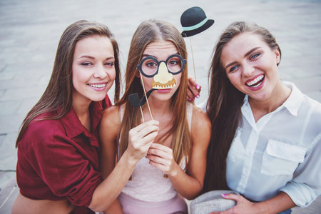 Three beautiful young women celebrating a birthday, outdoors