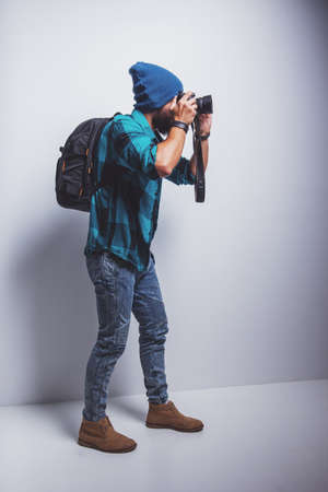 Young cheerful photographer with beard, while working in studioの写真素材