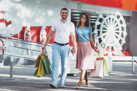 Loving young couple with bags for shopping, walk to townの写真素材