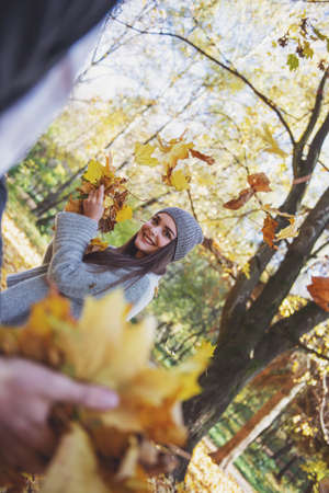 Young happy girl students while walking autumn parkの写真素材