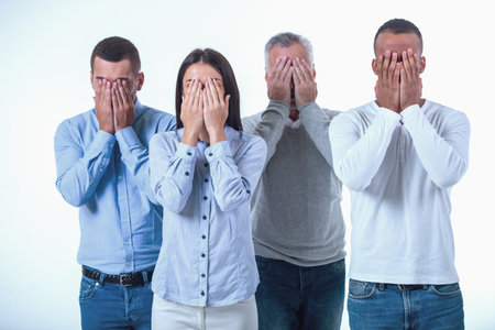 Beautiful business people in smart casual wear are covering their faces, isolated on whiteの写真素材