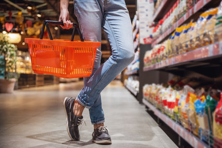 Cropped image of handsome man with a market basket doing shopping at the supermarketの写真素材