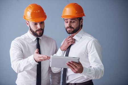 Handsome businessmen are using digital tablets, on gray background