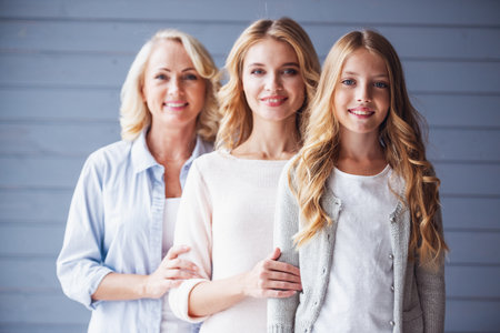 Beautiful women generation: granny, mom and daughter are looking at camera and smilingの写真素材
