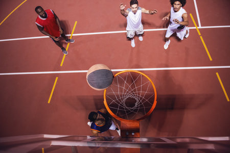 High angle view of handsome guys playing basketball outdoors at nightの写真素材