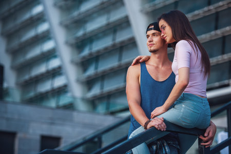 Stylish young couple is hugging and smiling while walking in the cityの写真素材