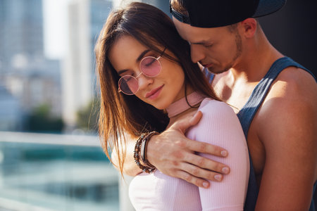Stylish young couple is hugging while walking in the cityの写真素材