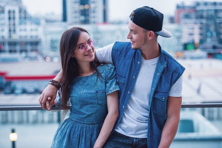 Stylish young couple is hugging, talking and smiling while walking in the cityの写真素材