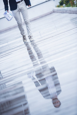 Cropped image of handsome businessman holding document while walking outdoorsの写真素材