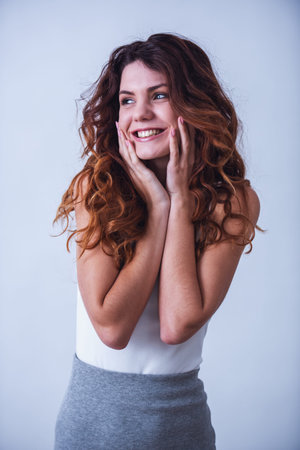 Portrait of happy beautiful young girl on white background. Smile at the camera.