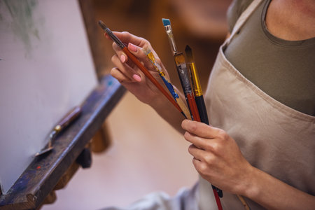 A young beautiful woman is a painting artist while working in a studioの写真素材