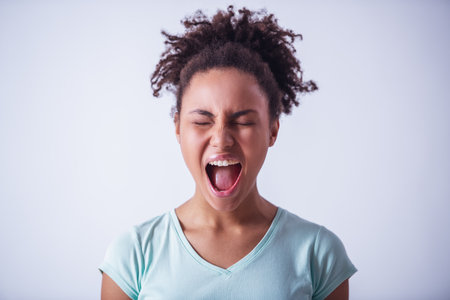 Beautiful girl in casual clothes is screaming, isolated on whiteの写真素材