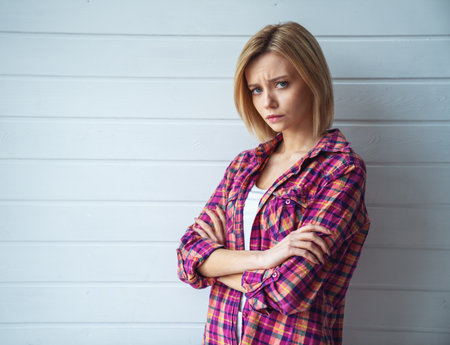 Portrait of young cheerful emotional beautiful blonde girl on light backgroundの写真素材