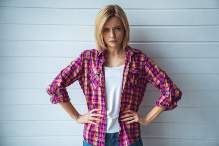 Portrait of young cheerful emotional beautiful blonde girl on light backgroundの写真素材