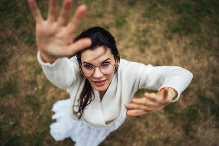 Retro style. Young beautiful girl with black chic hair in a white dress is looking at the camera, top view.の写真素材
