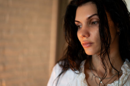 Portrait of a young beautiful sexy girl with black chic hair getting dressed at home in the bedroom.の写真素材
