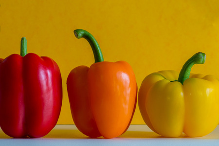 Colorful bell peppers in front of a colorful backgroundの写真素材