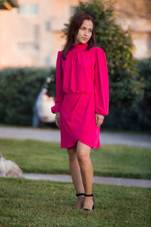 Young brunette woman in pose outdoors with elegant short dress and smiling.の写真素材