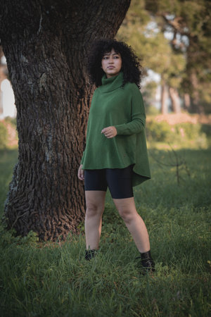 Young brunette woman in pose outdoors with elegant short dress and smiling.の写真素材