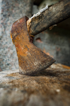 Old rusty ax on a wooden table in an old workshop. Selective focus.