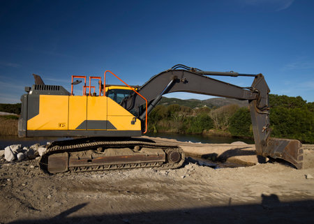 Excavator on a construction site on a background of blue sky.の写真素材