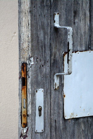 Old wooden door with white handle and lock