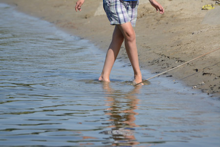 White women legs walking in the water at the beach