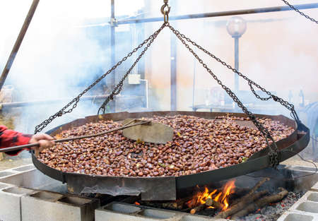 metal pan for cooking chestnuts on fireの写真素材