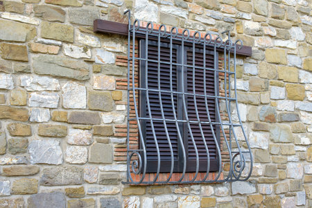 window with iron grating on stone wall
