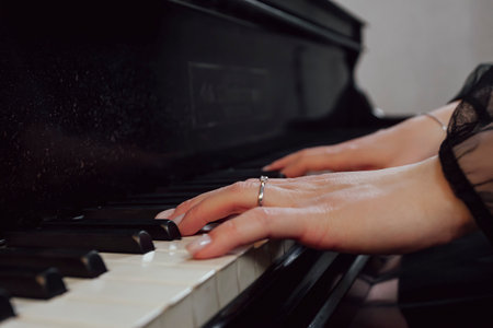 Close up of woman's hands playing piano.の写真素材