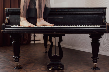 Woman's legs standing of a piano keys.の写真素材