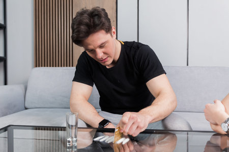 Drugs addiction. A young man taking drugs, having fun, snorting and sniffing cocaine lines, abuse of...
