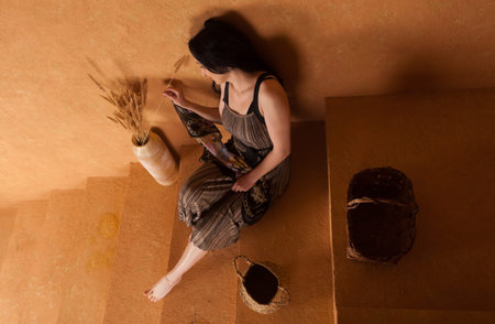 A woman wearing dress in a beige sandstone room. warm and cozy atmosphere.の写真素材
