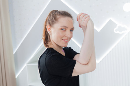 Young woman practicing yoga, working out, wearing sportswear, black top and pants, indoor full length, clear bright background. Sport and healthy active lifestyle concept.の写真素材