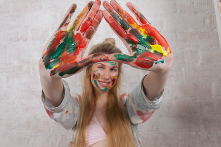 Talented Female Artist smiling happy showing colorful painted hands. Colorful, Emotional, Sensual Painter Creating Abstract Modern Art. Creative Expression concept.の写真素材
