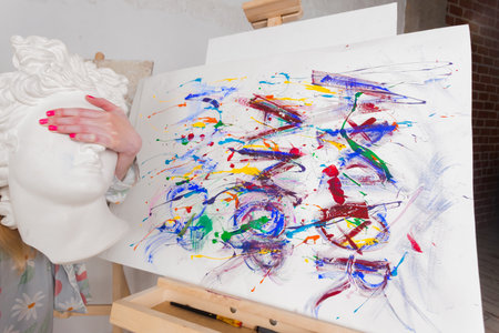 Hand of an artist holding marble head over a painting. Colorful, Emotional, Sensual Painter Creating Abstract Modern Art. Creative Expression concept.の写真素材