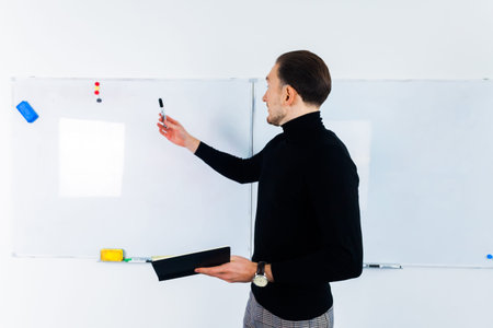 Entrepreneur Discussing Business Ideas and Plans on a Board. Looking at Results, Young Man Standing...