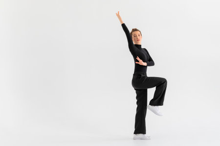 Young Girl, professional hip-hop dancer in a black clothes performing over a Isolated white background with a plenty of copy space.の写真素材