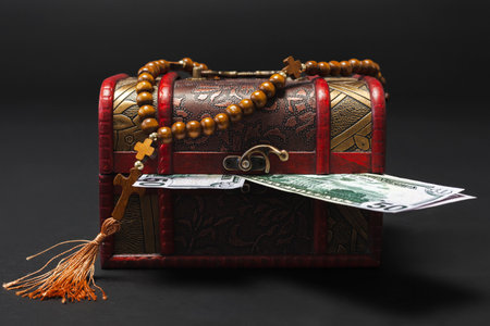 A wooden antique box filled with money, banknotes isolated on a black background. Copy space.の写真素材