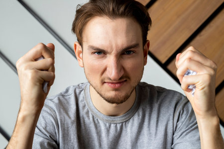 Angry office worker holding crumpled paper.の写真素材