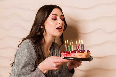 Close up portrait of a hungry young pregnant woman going to eat chocolate cake isolated on a gray backgroundの写真素材
