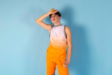 Photo of young man fooling around. using fruits instead of eyes. Sunglass, shirt, shorts, isolated blue color.の写真素材